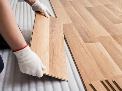pavimenti in legno laminato mentre vengono posati da un