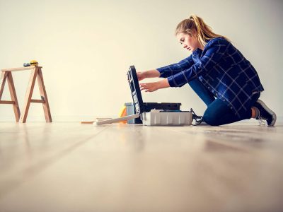 Una ragazza che posa il parquet vinilico realizzato da Parital, esperti del parquet a Torino.
